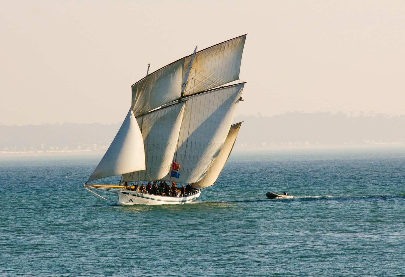 white sail boat sailing at the sea