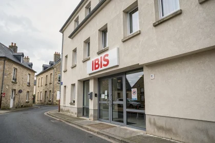 Façade extérieure de l'hôtel ibis à Fécamp avec l'enseigne rouge et blanche visible depuis la rue